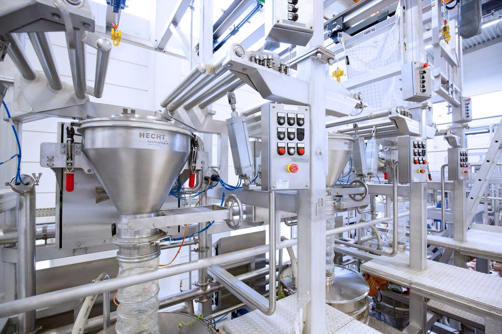 HECHT Technologie's AAS Outlet-Connection-System in an industrial setting, designed for low-dust discharging of FIBCs with enhanced double dust leakage protection, commonly used in pharmaceutical, chemical, and food industries to handle non-hazardous and dusty bulk solids safely and cleanly