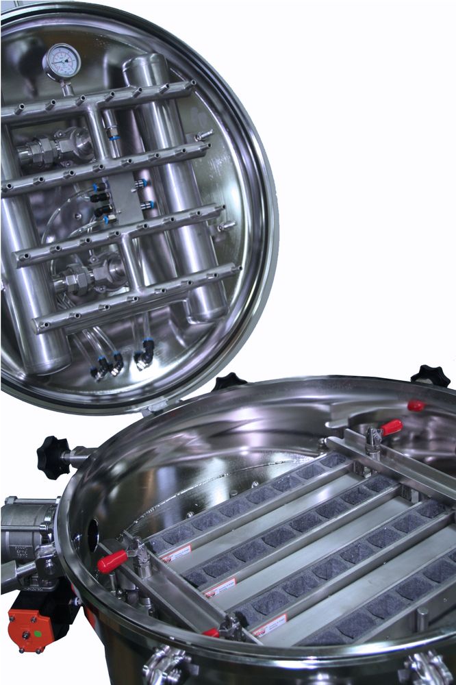 Interior view of an open PCC 700 vessel revealing intricate stainless steel piping and multiple filter elements. The vessel is equipped with pressure gauges and various connectors, designed for precision filtration in industrial processes.